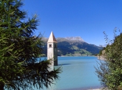 Der herausragende Kirchturm von Graun am Reschensee im Vinschgau als Wahrzeichen der Ferienregion Reschen